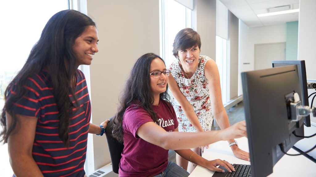 Students pointing at computer