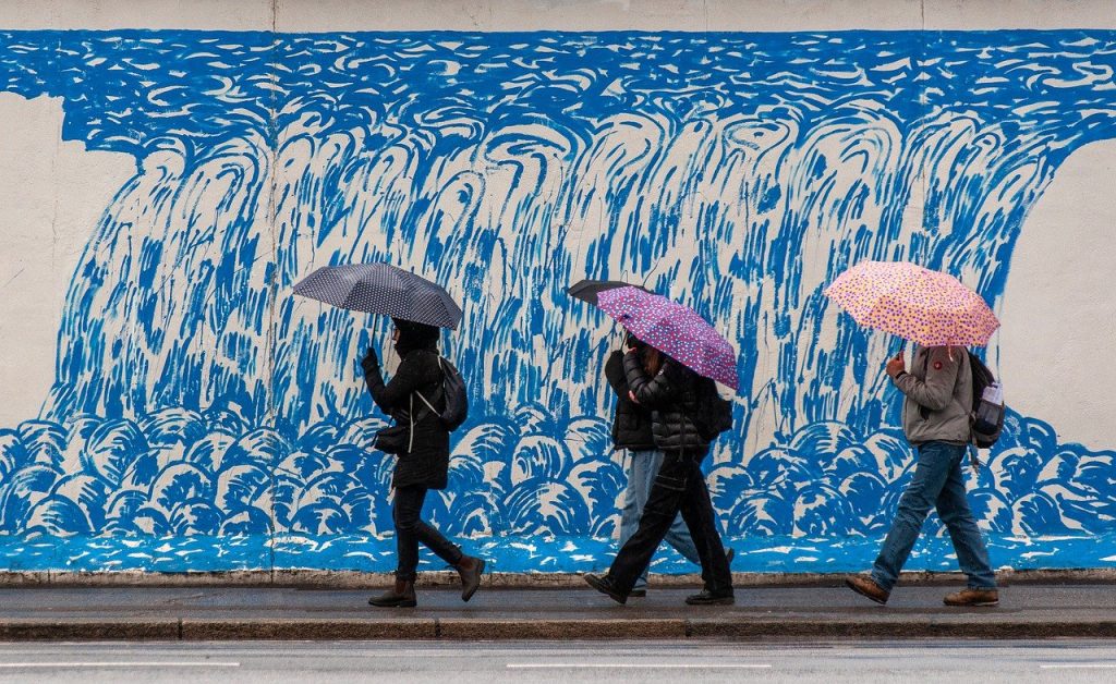 People walking on a street with different coloured umbrellas